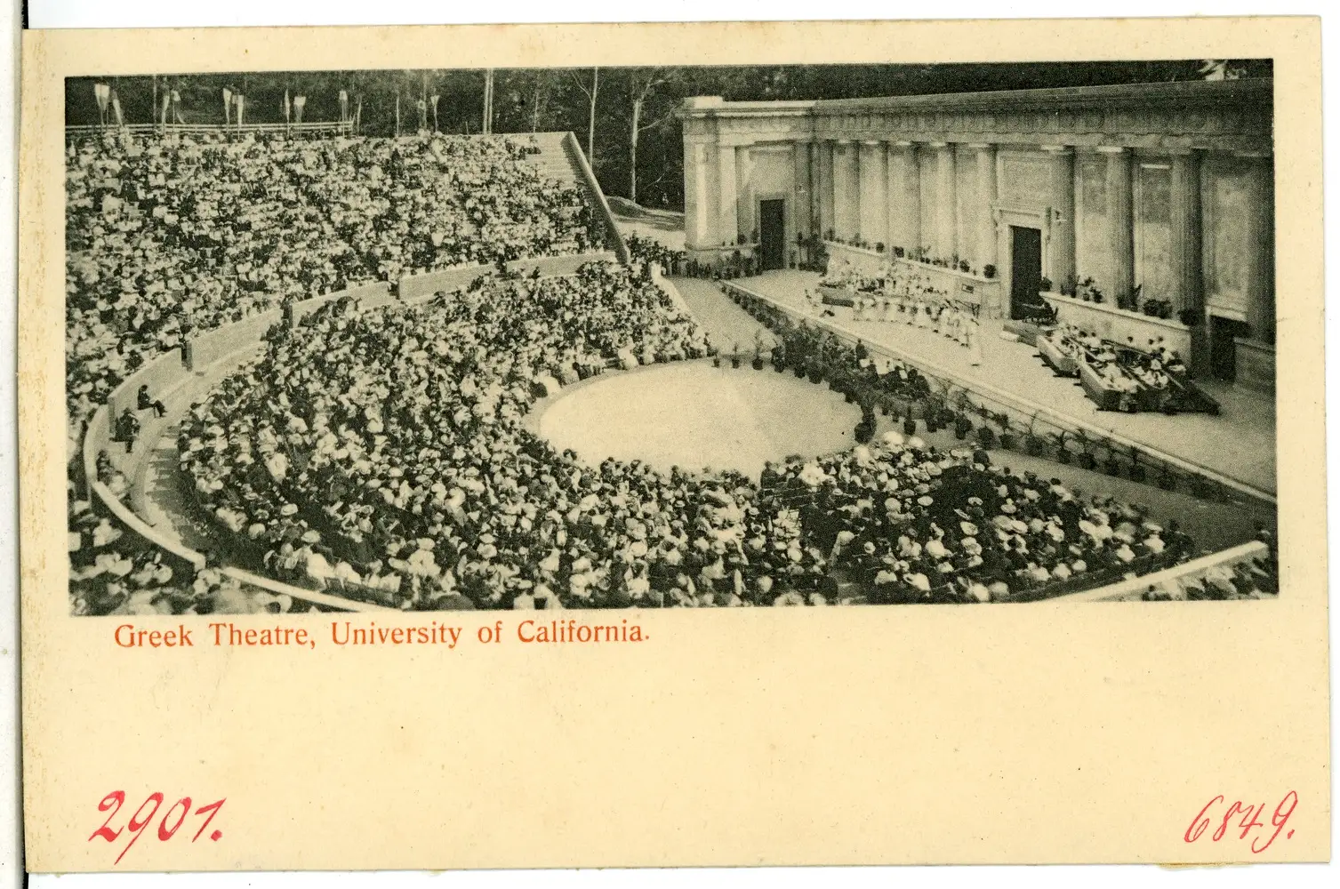 Postcard view of the Greek Theatre at the University of California, 1905: a packed semicircle of seated spectators in hats faces a stage with a columned wall, trees behind. Red printed title below the photograph.